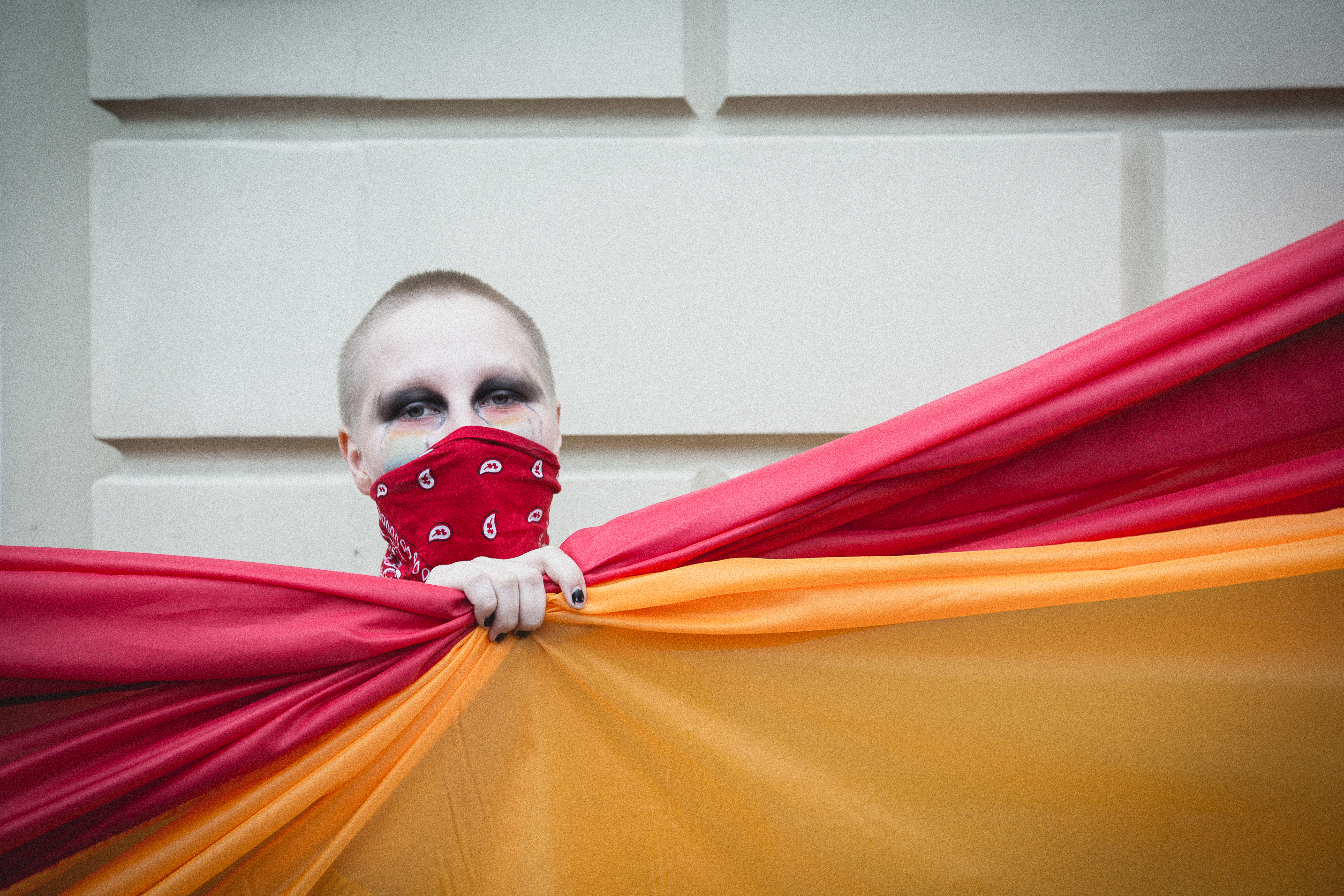 A protestor holding part of a giant pride flag, Warsaw, Poland. October 2020.