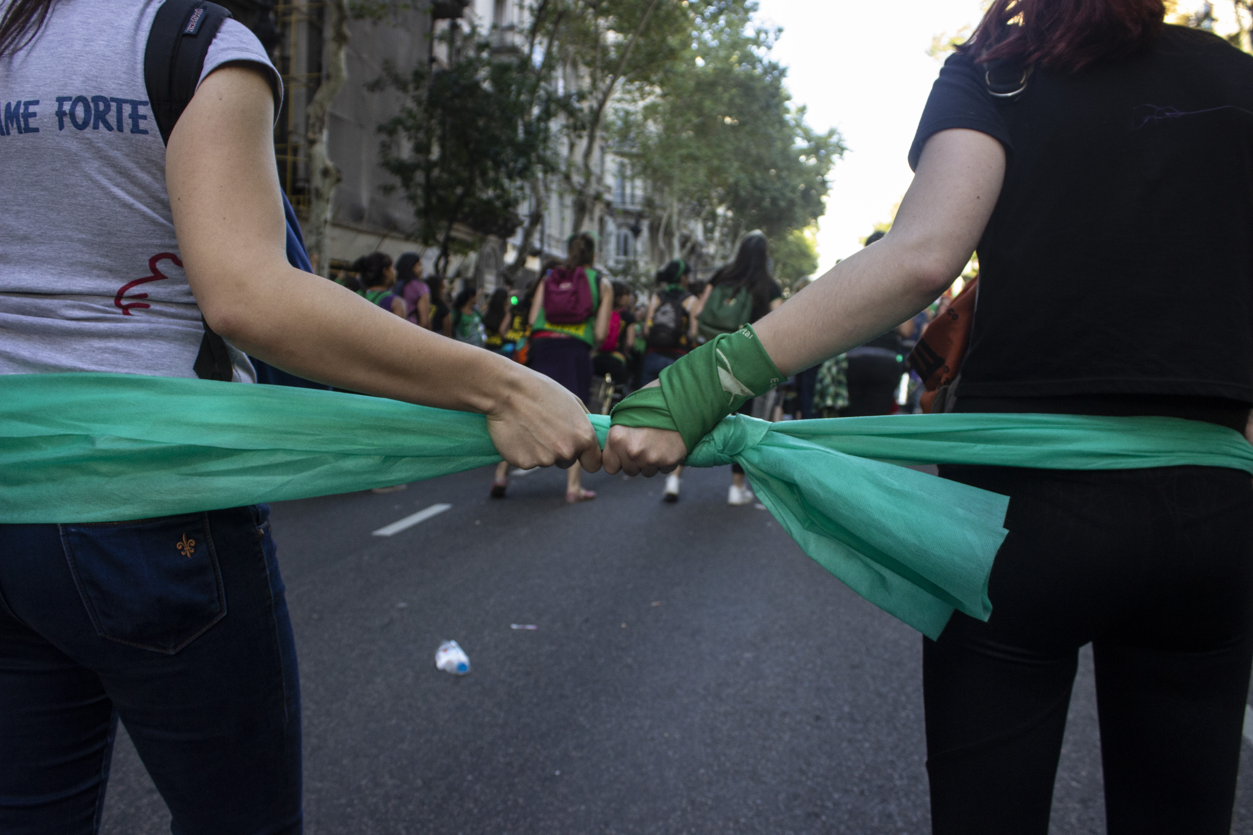 Two protestors hold a knotted piece of green fabric, Buenos Aires, Argentina, 8 March 2019.